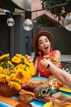 Hispanic woman enjoying a lively outdoor meal with Mexican food and decorations.